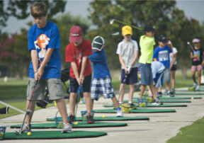 A line of children play golf during the annual Junior Golf Clinic on the Oaks Golf Course at Randolph Air Force Base, Joint Base San Antonio, Texas, June 13, 2012. The clinic is a recreational activity to teach children of U.S. service members or Department of Defense civilians the basics of golf and course etiquette. (U.S. Air Force photo by Benjamin Faske/Released)